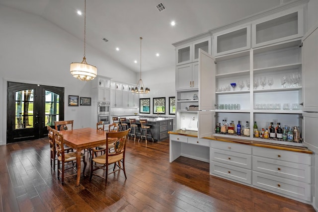 dining area featuring high vaulted ceiling, french doors, dark wood finished floors, and visible vents