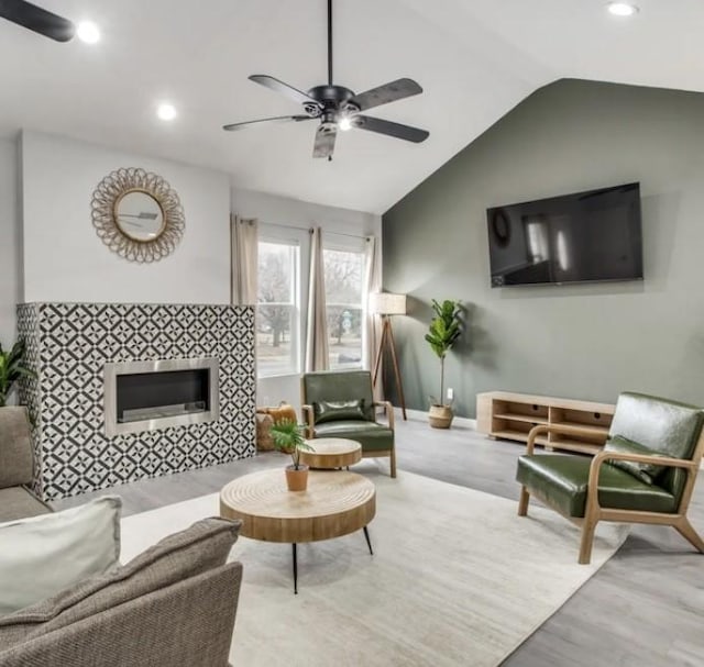 living area with ceiling fan, lofted ceiling, wood finished floors, recessed lighting, and baseboards