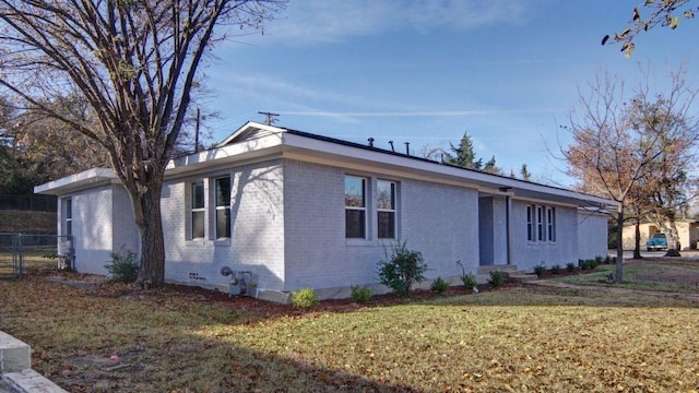 1327 W Water St, Weatherford, TX 76086 - view of side of property featuring a lawn, brick siding, and fence