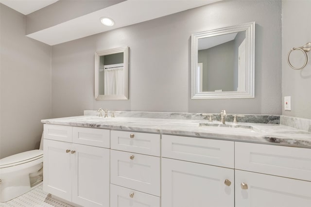 full bathroom with toilet, double vanity, and recessed lighting