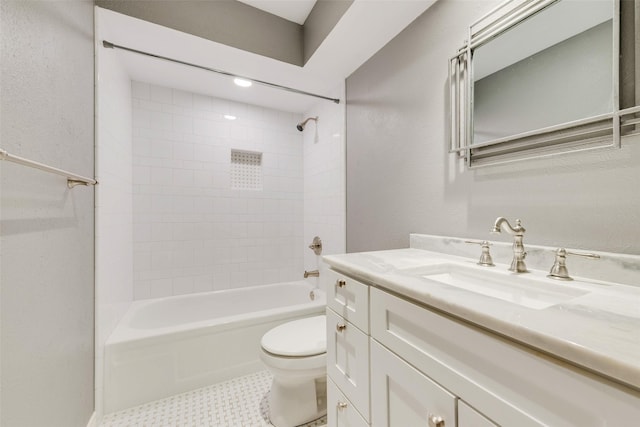 bathroom featuring toilet, shower / washtub combination, vanity, and a textured wall