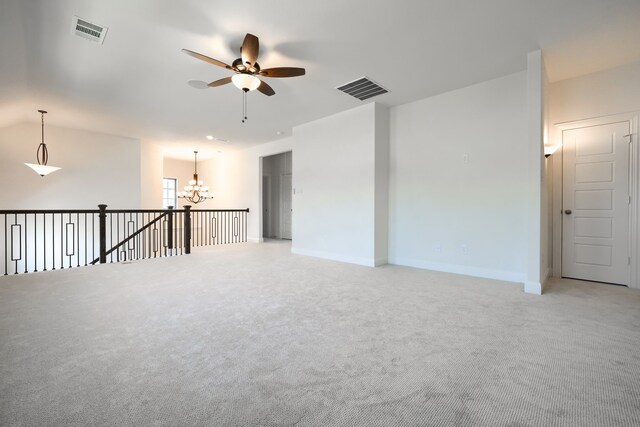 empty room featuring visible vents, light colored carpet, and ceiling fan with notable chandelier