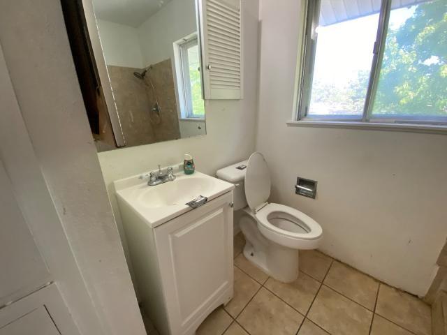 4219 Parkwood Dr, San Antonio, TX 78218 - bathroom with toilet, a shower, tile patterned flooring, and vanity