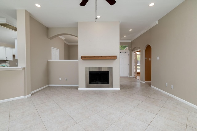 unfurnished living room with arched walkways, recessed lighting, light tile patterned floors, and a ceiling fan