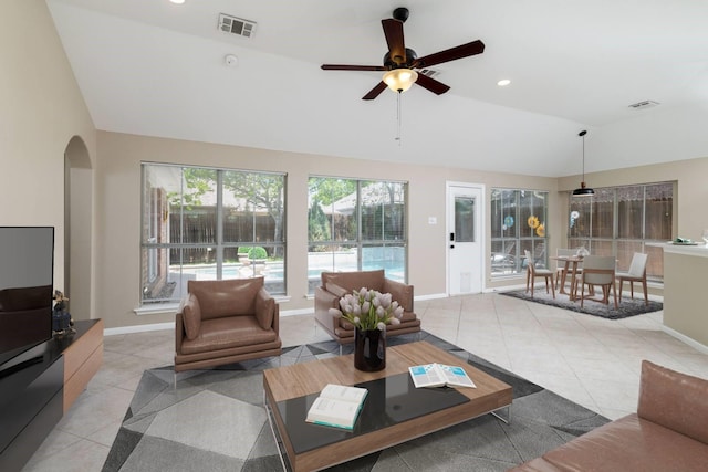 living area featuring visible vents, arched walkways, light tile patterned floors, and lofted ceiling