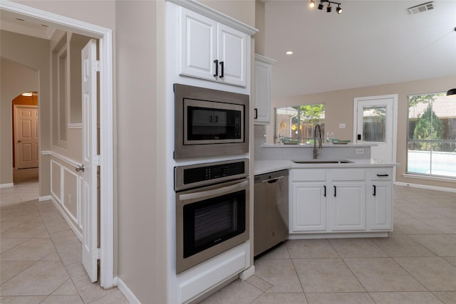 kitchen with tasteful backsplash, light tile patterned floors, visible vents, stainless steel appliances, and a sink