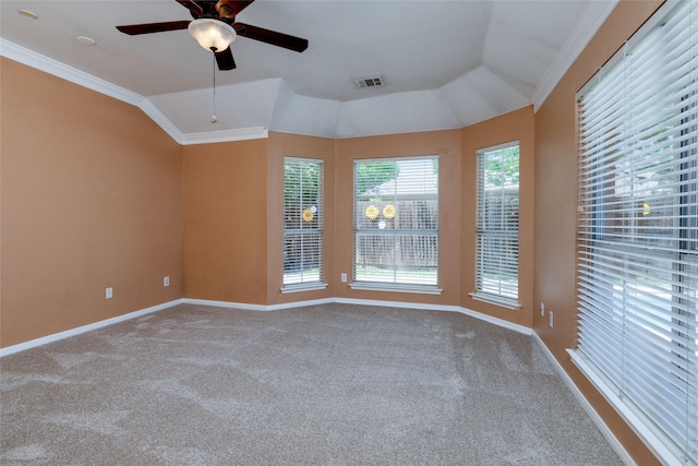 carpeted empty room featuring a ceiling fan, visible vents, ornamental molding, lofted ceiling, and baseboards