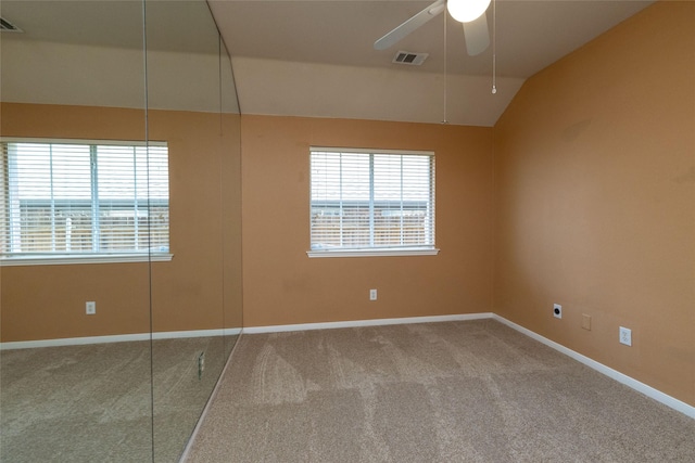 carpeted spare room featuring ceiling fan, baseboards, lofted ceiling, and visible vents