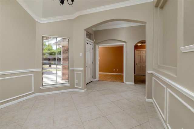 interior space with crown molding, light tile patterned floors, arched walkways, and a chandelier
