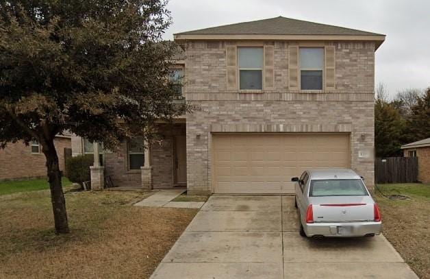traditional home featuring a front yard, an attached garage, brick siding, and concrete driveway