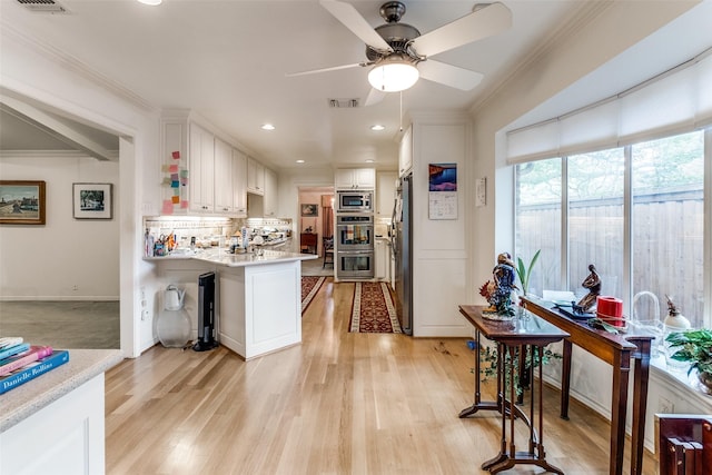 7261 Ashington Dr, Dallas, TX 75225 - kitchen with stainless steel appliances, light countertops, light wood finished floors, white cabinets, and ceiling fan