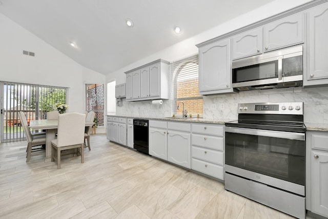 kitchen featuring backsplash, gray cabinetry, visible vents, stainless steel appliances, and a sink