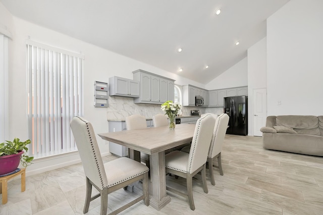 dining area with high vaulted ceiling and recessed lighting