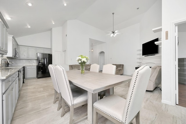 dining space with high vaulted ceiling, arched walkways, and ceiling fan