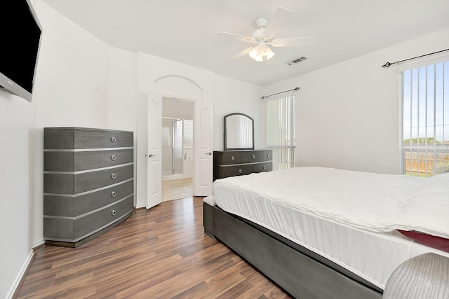 bedroom featuring visible vents, baseboards, a ceiling fan, and wood finished floors