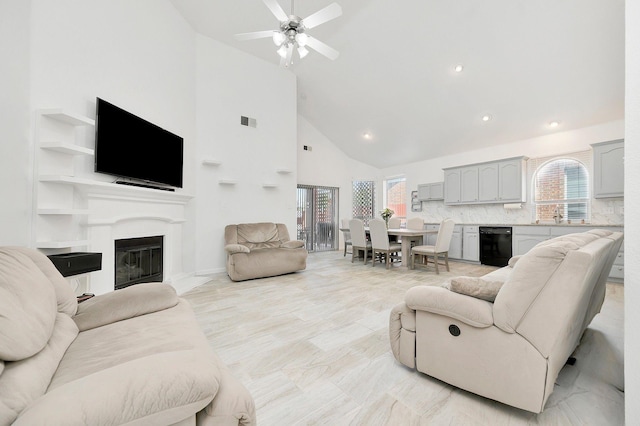 living room featuring a glass covered fireplace, recessed lighting, visible vents, ceiling fan, and high vaulted ceiling
