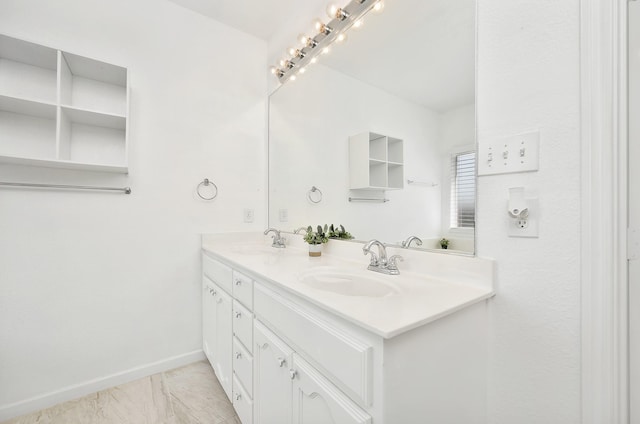 full bathroom featuring a sink, baseboards, double vanity, and marble finish floor