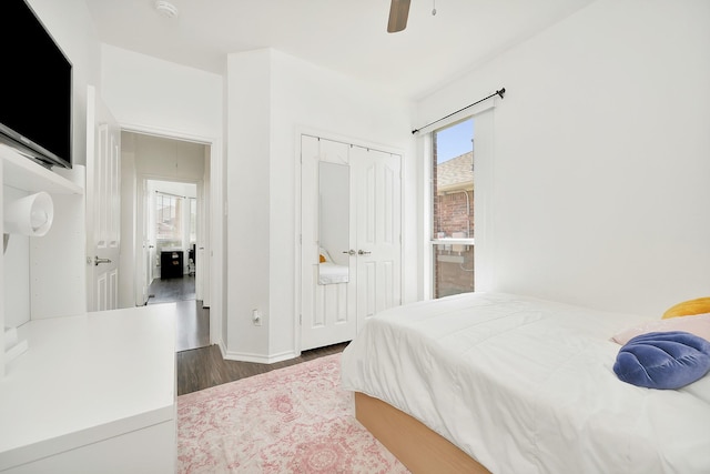 bedroom featuring ceiling fan, a closet, baseboards, and wood finished floors