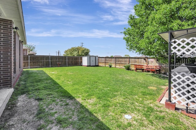 view of yard with a shed, a fenced backyard, and an outbuilding