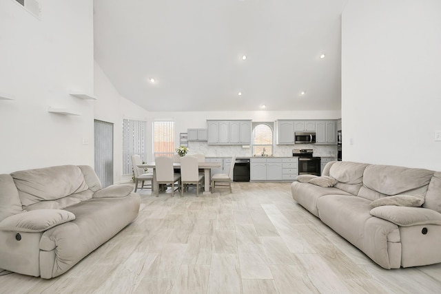 living room with high vaulted ceiling, visible vents, and recessed lighting