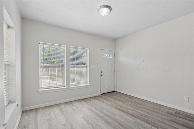 entrance foyer with baseboards and wood finished floors