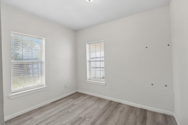 empty room with light wood-style flooring and baseboards
