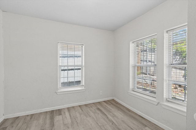 unfurnished room featuring baseboards and wood finished floors
