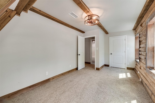 unfurnished bedroom with visible vents, baseboards, a chandelier, beam ceiling, and light carpet