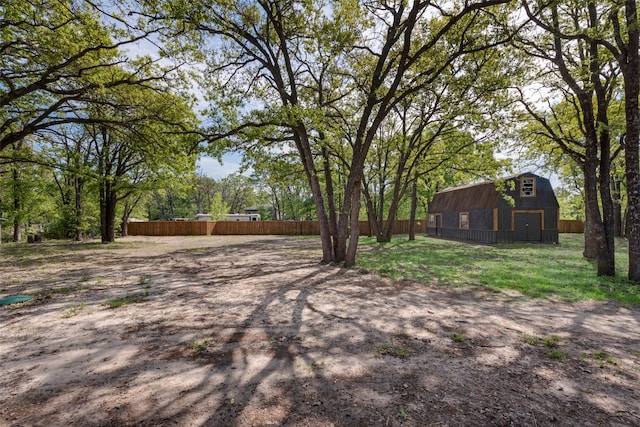 view of yard featuring an outdoor structure, fence, and a barn