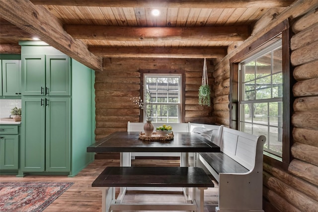 dining room featuring rustic walls, wooden ceiling, beamed ceiling, and breakfast area