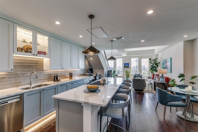 4611 Travis St Unit 1408B, Dallas, TX 75205 - kitchen featuring a sink, dishwasher, a kitchen breakfast bar, light stone countertops, and a kitchen island