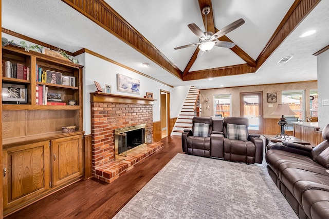 1409 Thames Dr, Plano, TX 75075 - living room with a brick fireplace, a ceiling fan, dark wood finished floors, a wainscoted wall, and lofted ceiling