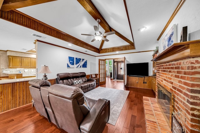 1409 Thames Dr, Plano, TX 75075 - living area featuring lofted ceiling with beams, a ceiling fan, visible vents, a brick fireplace, and hardwood / wood-style flooring