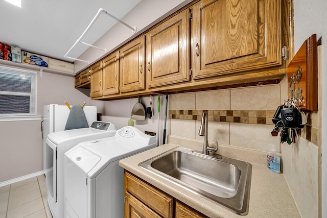 1409 Thames Dr, Plano, TX 75075 - washroom featuring light tile patterned floors, baseboards, a sink, independent washer and dryer, and cabinet space