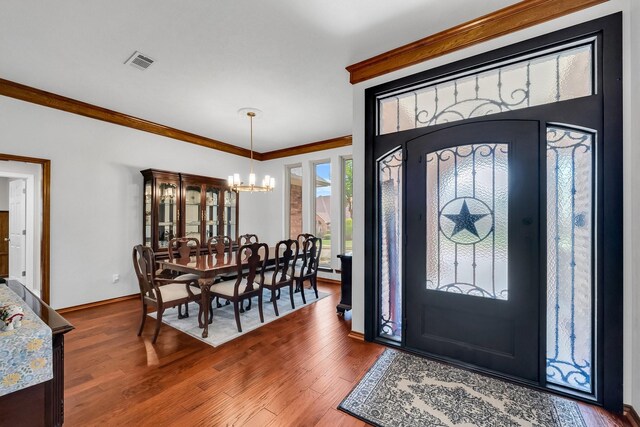 1409 Thames Dr, Plano, TX 75075 - foyer with baseboards, visible vents, a chandelier, wood finished floors, and ornamental molding