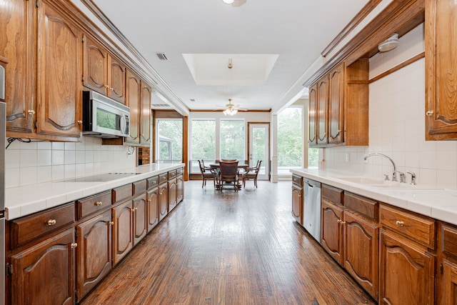5 Cypress Ct, Heath, TX 75032 - kitchen with stainless steel appliances, dark wood-style floors, tasteful backsplash, tile counters, and ornamental molding