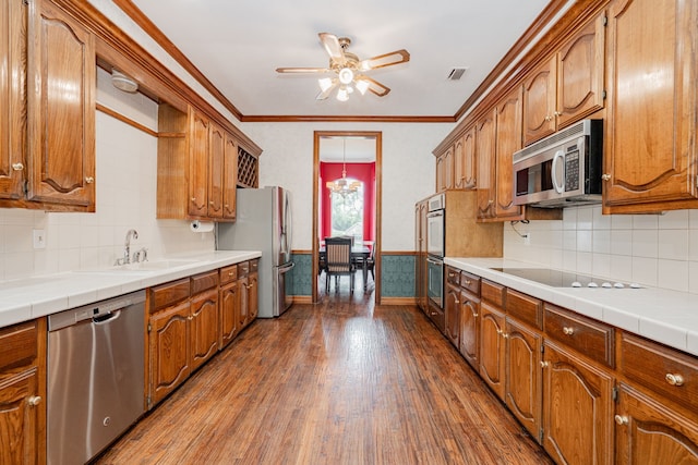 5 Cypress Ct, Heath, TX 75032 - kitchen with appliances with stainless steel finishes, dark wood-style flooring, a ceiling fan, ornamental molding, and brown cabinets