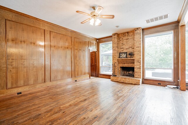 5 Cypress Ct, Heath, TX 75032 - unfurnished living room featuring crown molding, a ceiling fan, wood finished floors, a brick fireplace, and wooden walls