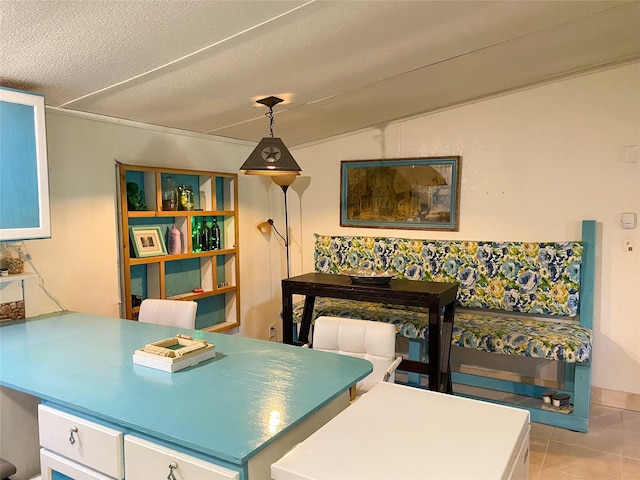 tiled dining space with a textured ceiling