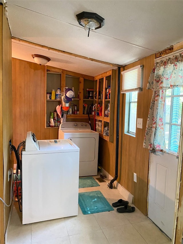 clothes washing area with wooden walls, washer and clothes dryer, and laundry area