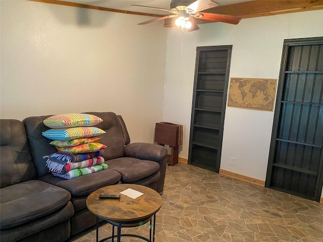 living area featuring stone finish flooring, baseboards, and ceiling fan