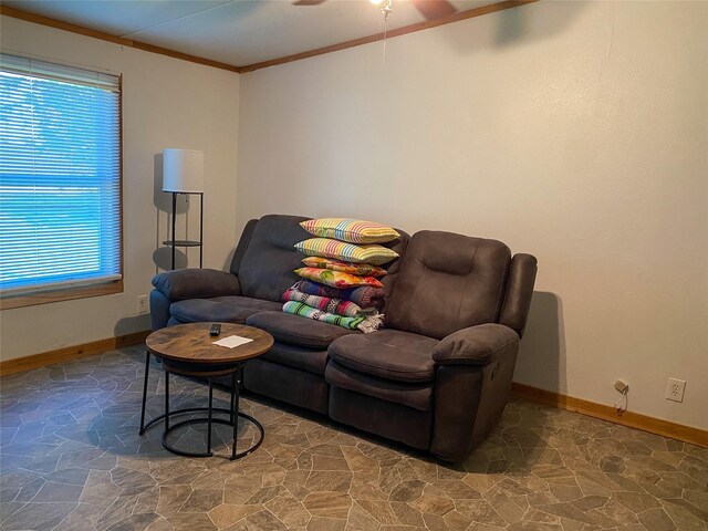 living area featuring crown molding, baseboards, a ceiling fan, and stone finish flooring