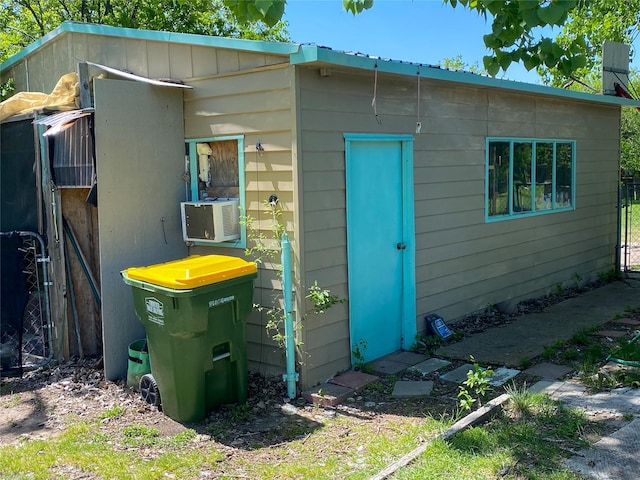 view of outbuilding featuring cooling unit, fence, and an outbuilding