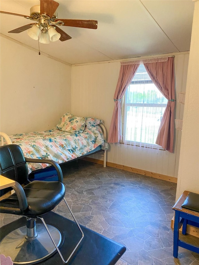 bedroom featuring stone floors, ceiling fan, and baseboards