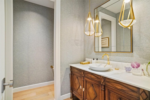 bathroom with wood finished floors, vanity, and baseboards