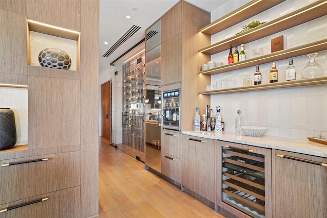 bar with a dry bar, wine cooler, visible vents, and light wood finished floors