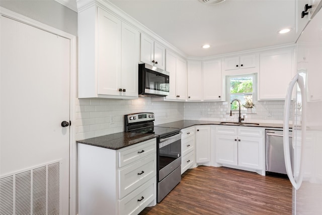kitchen featuring dark wood-style floors, a sink, white cabinetry, and stainless steel appliances