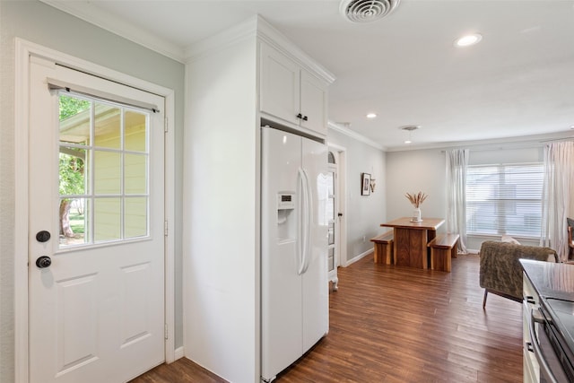 interior space featuring visible vents, baseboards, ornamental molding, and dark wood finished floors