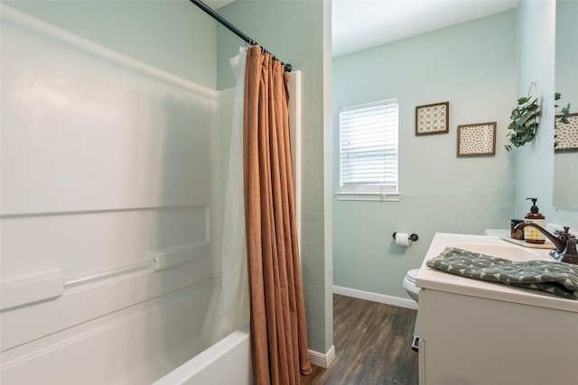 bathroom featuring baseboards, toilet, shower / bathtub combination with curtain, vanity, and wood finished floors