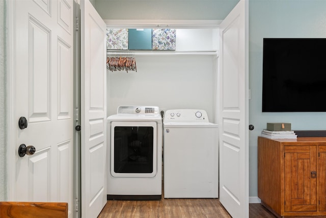 laundry area featuring separate washer and dryer, laundry area, and wood finished floors